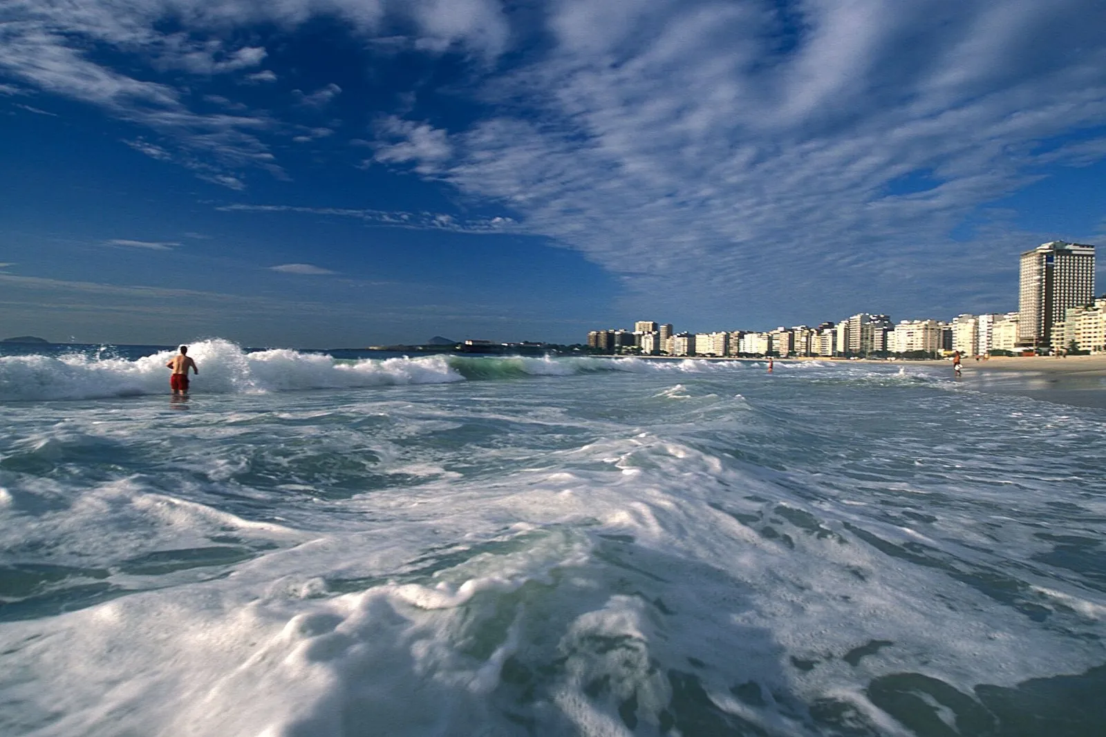 Copacabana beach with the seafront wall of apartment buildings on Avenida Atlântica behind the surf
